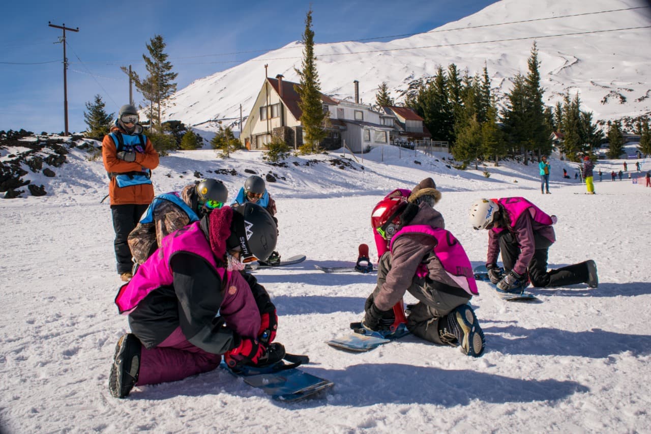 Voluntario ayudando a ajustar una bota de ski
