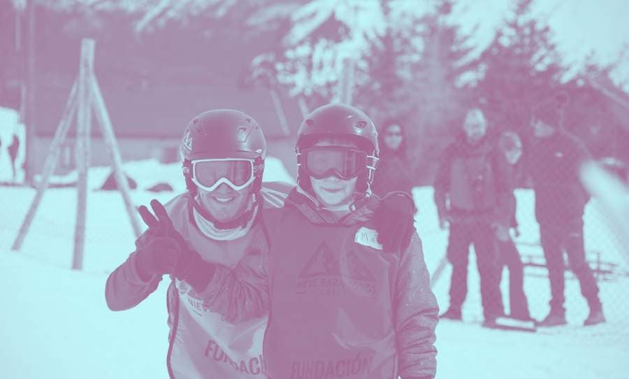Francisco Castillo junto a un estudiante en un terreno en la nieve.